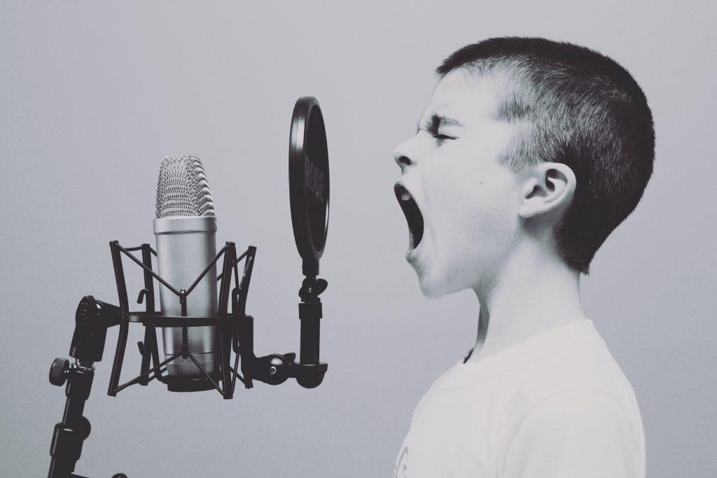 En pojke som sjunger i en mikrofon.